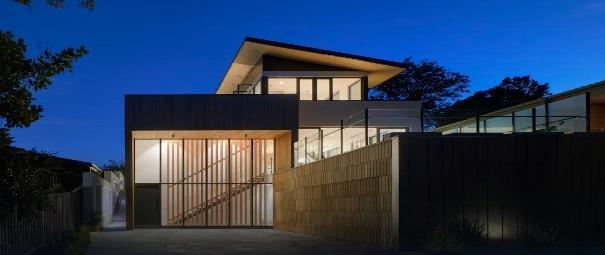 Modern two-story home lit up at dusk